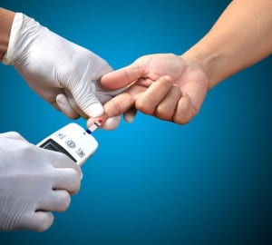 Doctor testing a patients glucose level after pricking his finge